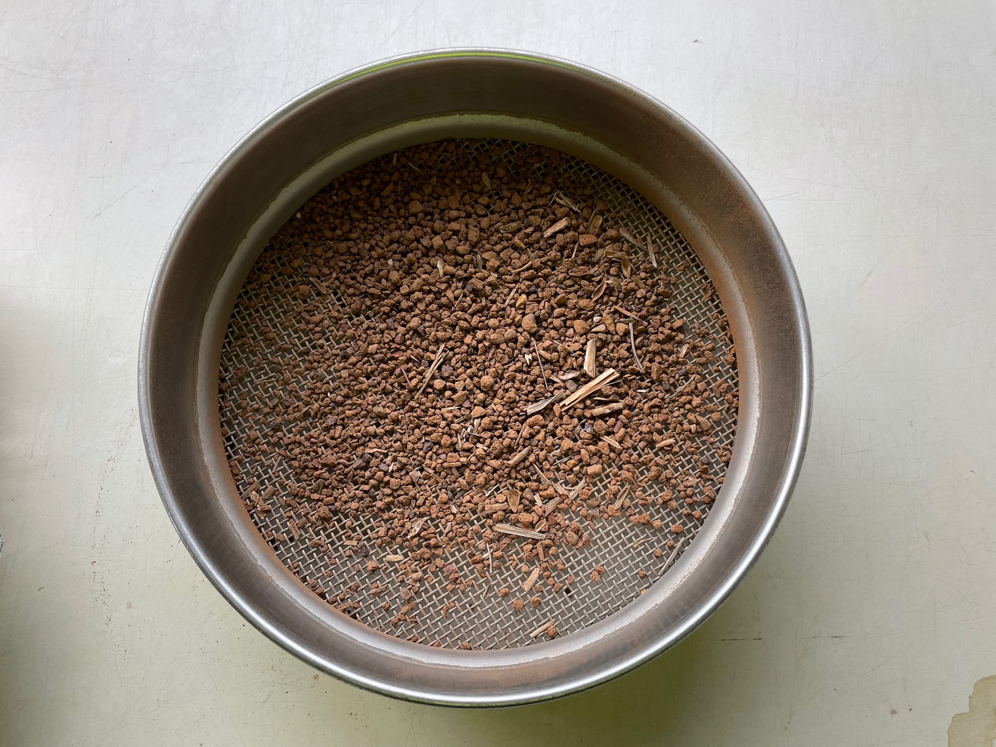2mm sieve with soil and plant material remaining after a sample was sieved.